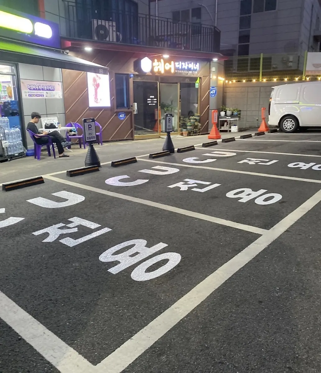 상가 앞 아스팔트 주차구획의 흰색 선과 글자 표시