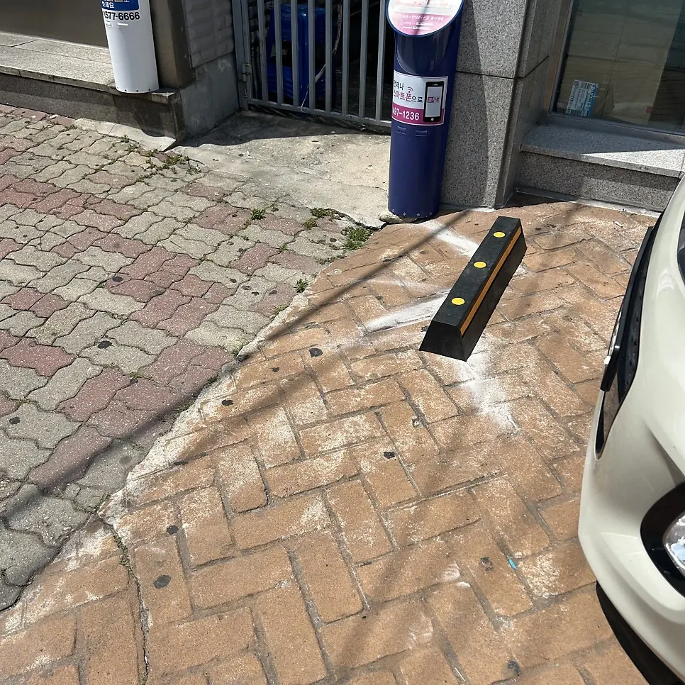 건물 출입구 앞 벽돌 포장 바닥의 차량 스토퍼